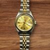 Rolex Lady Date gold and silver wristwatch with date display.