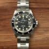 Vintage Tudor Submariner watch with black dial and stainless steel bracelet.